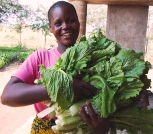 Woman smiling holding Chinese cabbage.
